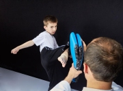 The coach teaches the athlete to hit the simulator